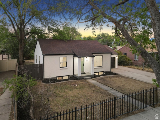 1043 S 1300 W, Salt Lake City, UT 84104 - view of front of property featuring brick siding, driveway, a fenced front yard, and a shingled roof