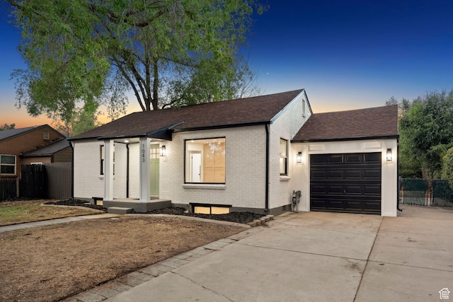 1043 S 1300 W, Salt Lake City, UT 84104 - view of front of home with driveway, a garage, brick siding, and roof with shingles
