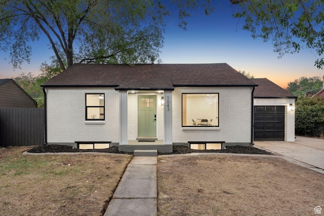 1043 S 1300 W, Salt Lake City, UT 84104 - view of front of house with brick siding, driveway, a shingled roof, and an attached garage