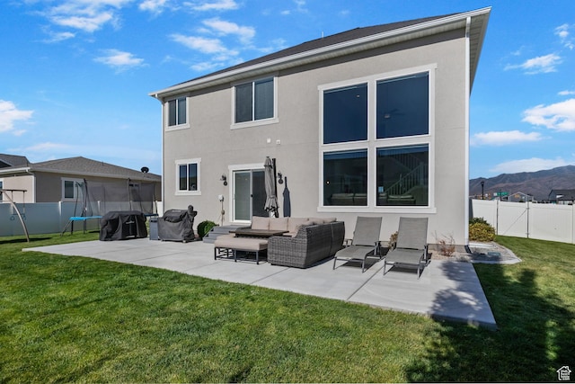 4982 N Goosefoot Dr Unit 51, Eagle Mountain, UT 84005 - rear view of house featuring a patio, stucco siding, a fenced backyard, and a trampoline