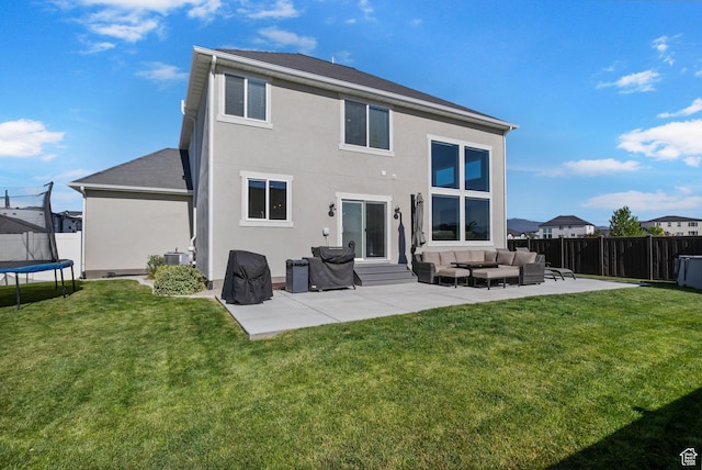 4982 N Goosefoot Dr Unit 51, Eagle Mountain, UT 84005 - rear view of house featuring a trampoline, outdoor lounge area, a fenced backyard, and a patio