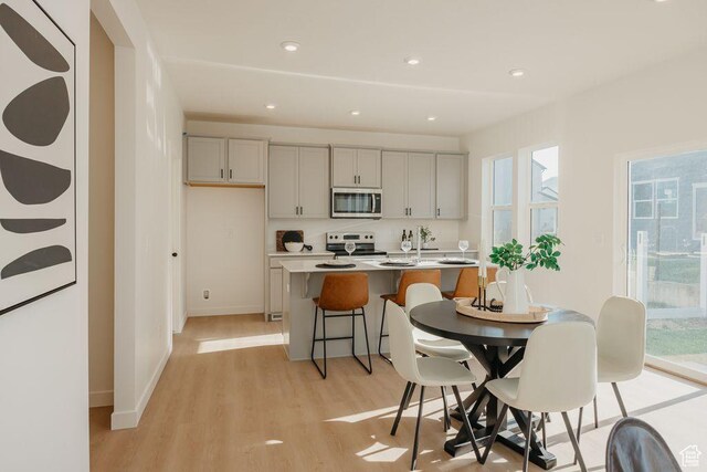 3620 N Stallion St Unit 349, Eagle Mountain, UT 84005 - kitchen with stainless steel microwave, electric range oven, gray cabinets, light wood-type flooring, and light countertops