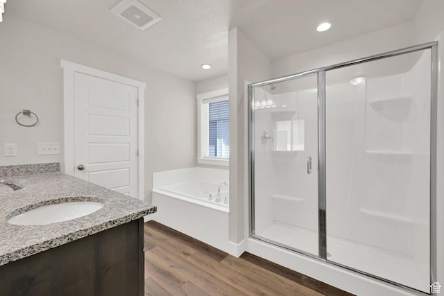 2782 W 4140 S Unit 246, Roy, UT 84067 - bathroom featuring a shower stall, wood finished floors, a bath, vanity, and recessed lighting
