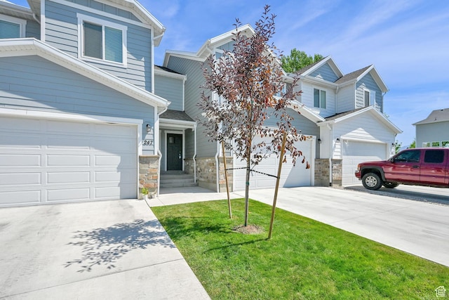 2782 W 4140 S Unit 246, Roy, UT 84067 - view of front of home featuring concrete driveway, stone siding, a front yard, and an attached garage