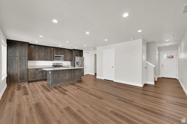 2782 W 4140 S Unit 246, Roy, UT 84067 - kitchen with stainless steel appliances, recessed lighting, a center island with sink, light countertops, and wood finished floors