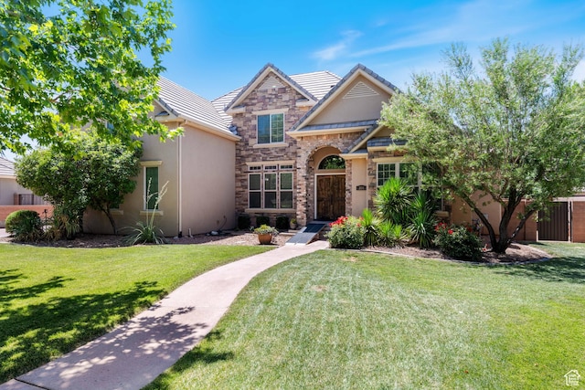 358 S 1040 W, Hurricane, UT 84737 - traditional home featuring stone siding, a front yard, stucco siding, and a tiled roof