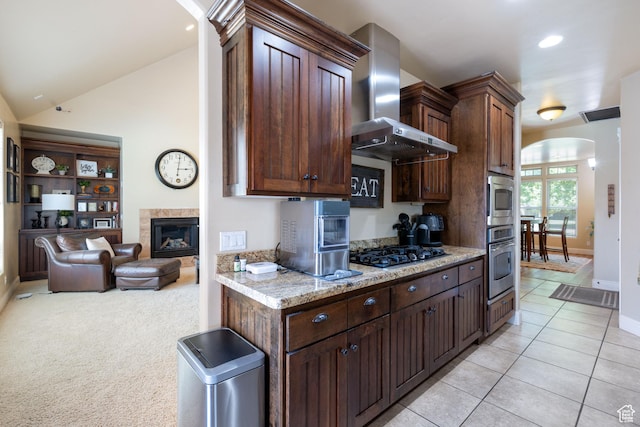 358 S 1040 W, Hurricane, UT 84737 - kitchen featuring arched walkways, appliances with stainless steel finishes, wall chimney range hood, light tile patterned flooring, and light stone countertops
