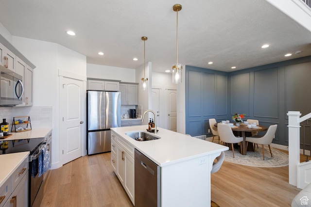 13568 S Vernet Dr W Unit 1824, Riverton, UT 84096 - kitchen with appliances with stainless steel finishes, light wood-type flooring, a decorative wall, light countertops, and backsplash