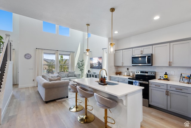 13568 S Vernet Dr W Unit 1824, Riverton, UT 84096 - kitchen featuring appliances with stainless steel finishes, gray cabinets, backsplash, open floor plan, and light countertops