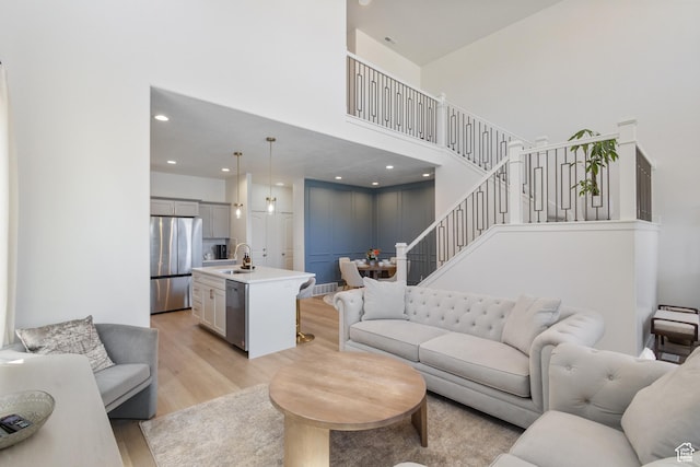 13568 S Vernet Dr W Unit 1824, Riverton, UT 84096 - living room featuring a high ceiling, light wood-type flooring, stairs, and recessed lighting