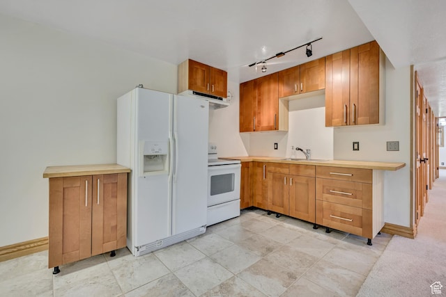 3697 Wagon Wheel Way, Park City, UT 84098 - kitchen featuring white appliances, under cabinet range hood, rail lighting, light countertops, and brown cabinets