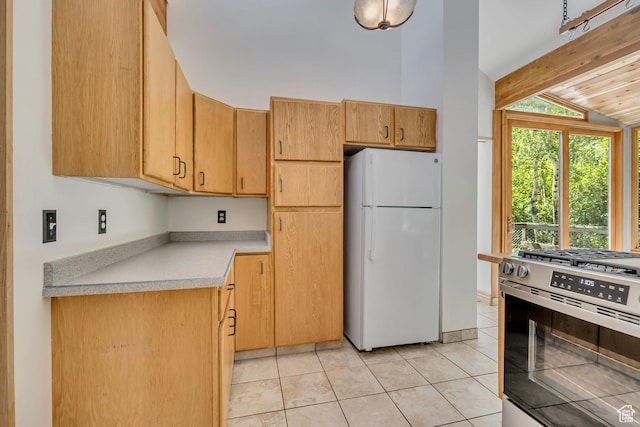 3697 Wagon Wheel Way, Park City, UT 84098 - kitchen with freestanding refrigerator, stainless steel range with gas stovetop, light countertops, and light tile patterned floors
