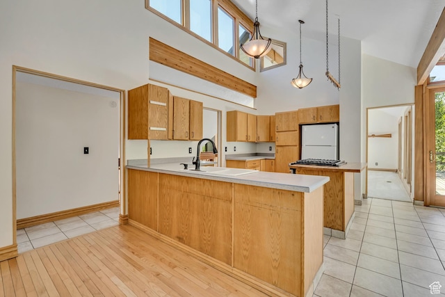 3697 Wagon Wheel Way, Park City, UT 84098 - kitchen featuring high vaulted ceiling, white refrigerator, a peninsula, light countertops, and pendant lighting