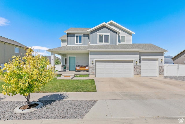 4857 N Goosefoot Dr, Eagle Mountain, UT 84005 - view of front of home with driveway, board and batten siding, covered porch, a garage, and stone siding