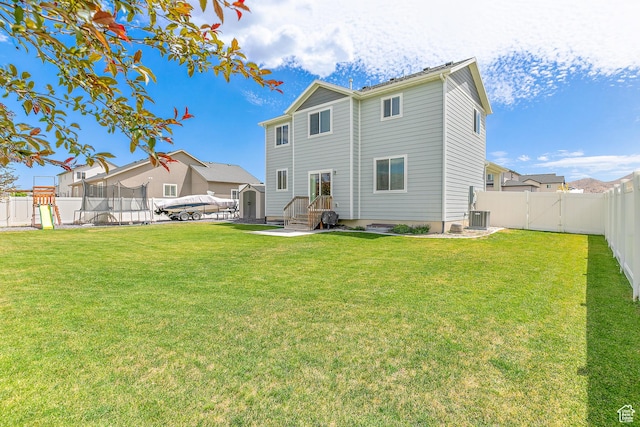 4857 N Goosefoot Dr, Eagle Mountain, UT 84005 - back of house featuring a trampoline, a fenced backyard, a storage unit, and a playground