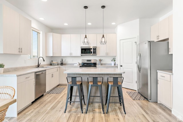4857 N Goosefoot Dr, Eagle Mountain, UT 84005 - kitchen with stainless steel appliances, a center island, a kitchen breakfast bar, light wood-style floors, and light countertops