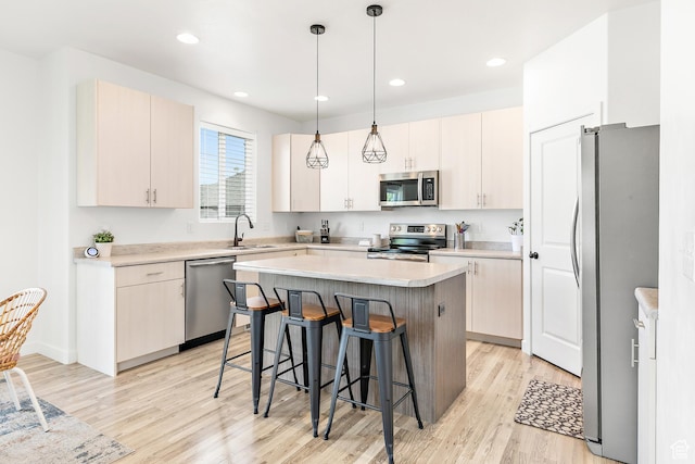 4857 N Goosefoot Dr, Eagle Mountain, UT 84005 - kitchen featuring stainless steel appliances, a breakfast bar, a kitchen island, light wood-style flooring, and hanging light fixtures