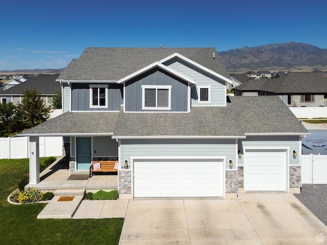 4857 N Goosefoot Dr, Eagle Mountain, UT 84005 - view of front of home featuring stone siding, a shingled roof, driveway, and covered porch