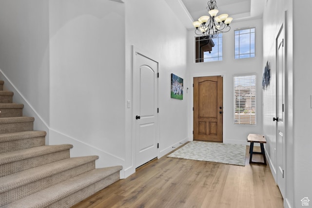 4323 W 2650th Cir S, Hurricane, UT 84737 - foyer entrance featuring stairway, a chandelier, light wood-style floors, a tray ceiling, and a high ceiling