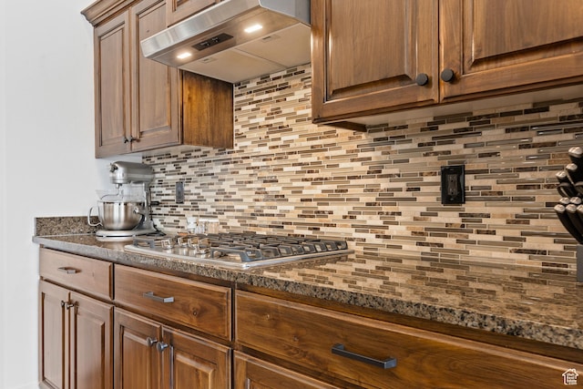 4323 W 2650th Cir S, Hurricane, UT 84737 - kitchen with ventilation hood, backsplash, stainless steel gas cooktop, and dark stone countertops