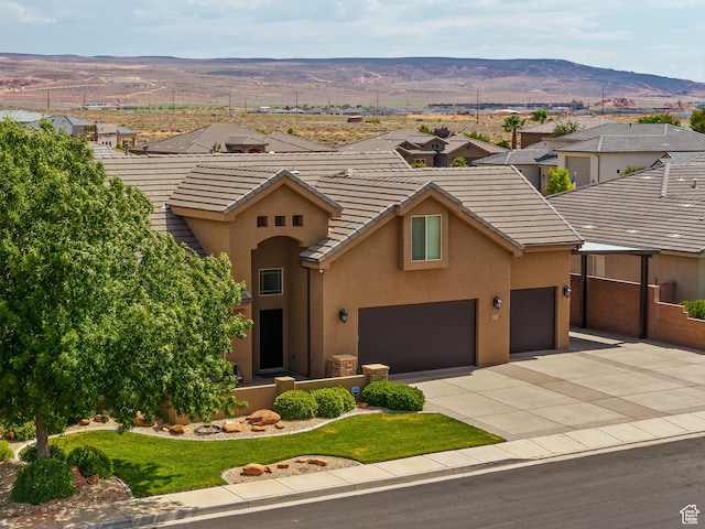 4323 W 2650th Cir S, Hurricane, UT 84737 - view of front facade with stucco siding, a mountain view, driveway, a tile roof, and a front yard