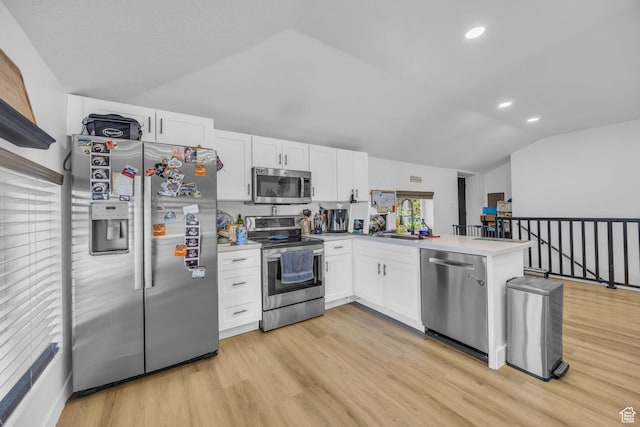 450 E 32 S, Ogden, UT 84401 - kitchen featuring appliances with stainless steel finishes, lofted ceiling, a peninsula, white cabinets, and light wood-type flooring