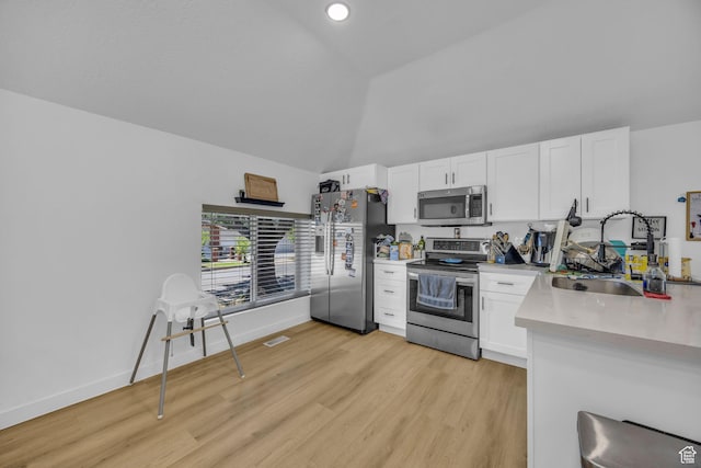 450 E 32 S, Ogden, UT 84401 - kitchen featuring appliances with stainless steel finishes, white cabinets, light countertops, light wood finished floors, and high vaulted ceiling