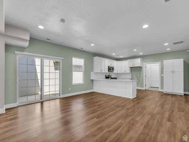 5103 W Black Twig Dr, South Jordan, UT 84009 - kitchen featuring stainless steel microwave, a peninsula, stove, white cabinetry, and recessed lighting