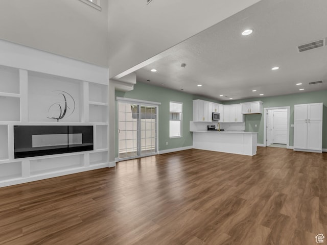 5103 W Black Twig Dr, South Jordan, UT 84009 - unfurnished living room featuring recessed lighting, dark wood-type flooring, built in features, and a fireplace