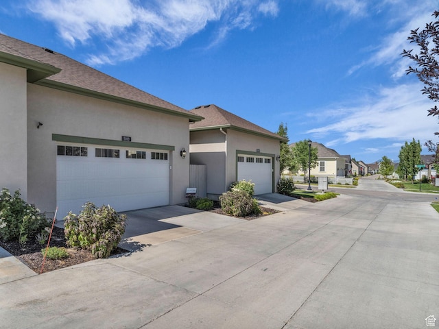 5103 W Black Twig Dr, South Jordan, UT 84009 - view of property exterior with stucco siding, a garage, concrete driveway, a residential view, and a shingled roof