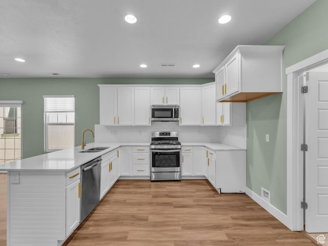 5103 W Black Twig Dr, South Jordan, UT 84009 - kitchen with appliances with stainless steel finishes, a peninsula, light countertops, white cabinets, and recessed lighting