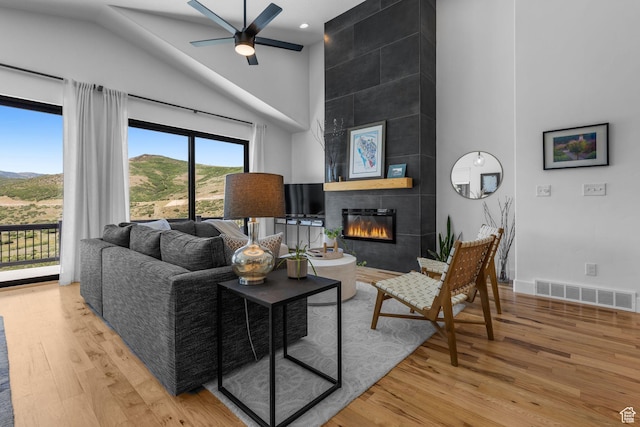 12403 Ross Creek Dr, Kamas, UT 84036 - living area featuring high vaulted ceiling, wood finished floors, a tile fireplace, a ceiling fan, and a mountain view