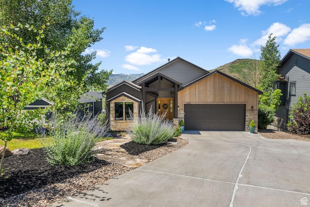 12403 Ross Creek Dr, Kamas, UT 84036 - view of front facade featuring concrete driveway, a garage, stone siding, and a mountain view