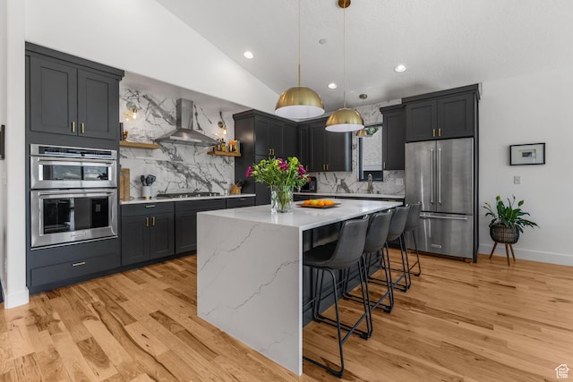 12403 Ross Creek Dr, Kamas, UT 84036 - kitchen with appliances with stainless steel finishes, wall chimney exhaust hood, vaulted ceiling, a center island, and decorative backsplash