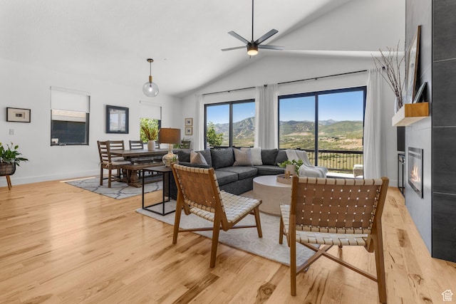 12403 Ross Creek Dr, Kamas, UT 84036 - living area with light wood-style flooring, vaulted ceiling, a large fireplace, a ceiling fan, and a mountain view