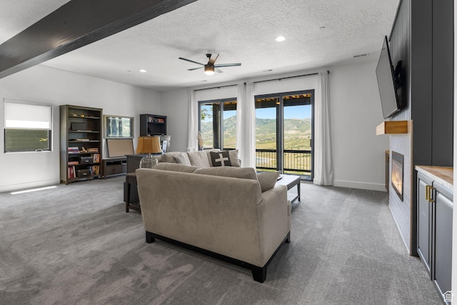 12403 Ross Creek Dr, Kamas, UT 84036 - living room with carpet, a fireplace, a textured ceiling, ceiling fan, and recessed lighting