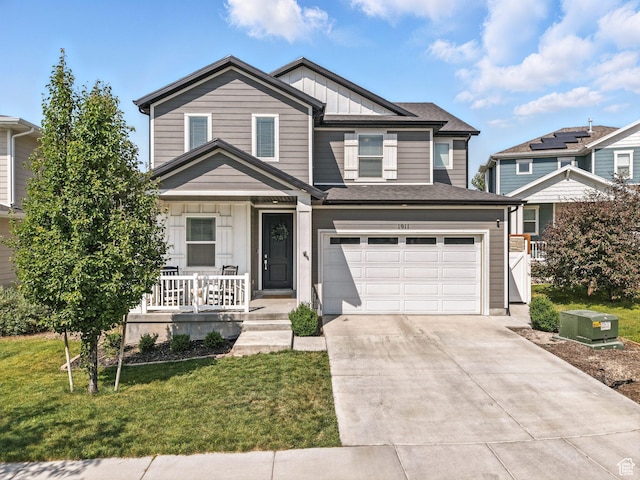 1911 N Lemongrass Dr, Saratoga Springs, UT 84045 - view of front facade featuring covered porch, board and batten siding, concrete driveway, a front lawn, and a garage