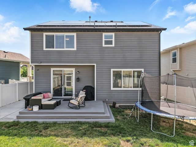 1911 N Lemongrass Dr, Saratoga Springs, UT 84045 - back of house with a trampoline, an outdoor hangout area, a wooden deck, and solar panels