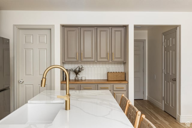 1012 N Cambria Dr, North Salt Lake, UT 84054 - kitchen featuring tasteful backsplash, light wood-style flooring, and light stone countertops