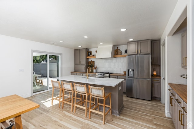 1012 N Cambria Dr, North Salt Lake, UT 84054 - kitchen featuring stainless steel appliances, custom exhaust hood, open shelves, tasteful backsplash, and light wood-type flooring