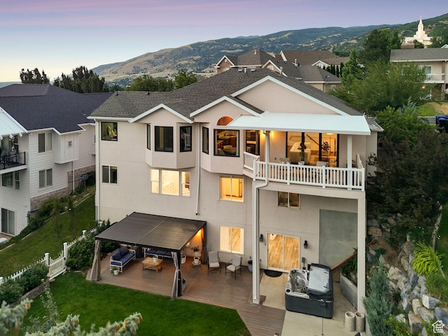 1044 S Terrace Dr E, Bountiful, UT 84010 - back of property featuring a balcony, stucco siding, an outdoor hangout area, and a mountain view