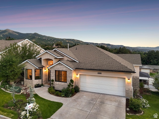 1044 S Terrace Dr E, Bountiful, UT 84010 - view of front of home with stone siding, a garage, driveway, a mountain view, and roof with shingles