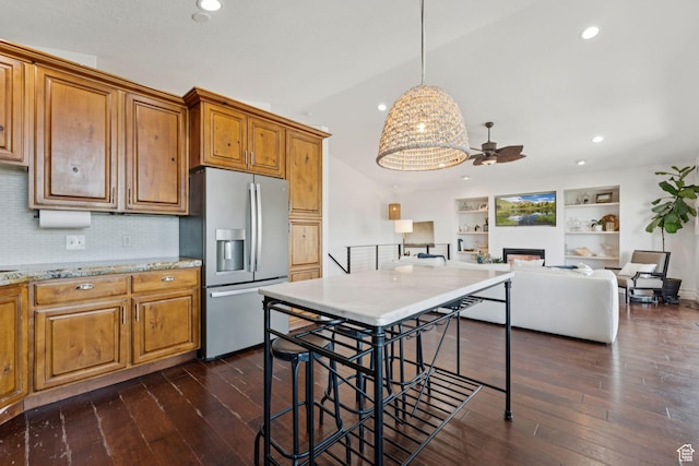 1044 S Terrace Dr E, Bountiful, UT 84010 - kitchen featuring stainless steel refrigerator with ice dispenser, ceiling fan, a fireplace, dark wood-style floors, and brown cabinetry