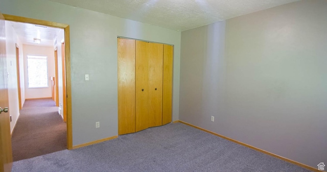558 E 2025 N, North Ogden, UT 84414 - unfurnished bedroom featuring carpet floors, a textured ceiling, and a closet