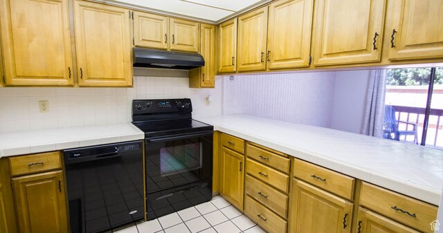 558 E 2025 N, North Ogden, UT 84414 - kitchen with under cabinet range hood, black appliances, light tile patterned floors, and decorative backsplash