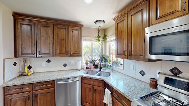 1605 W 1400 S, Vernal, UT 84078 - kitchen with appliances with stainless steel finishes, brown cabinetry, tasteful backsplash, and light stone countertops
