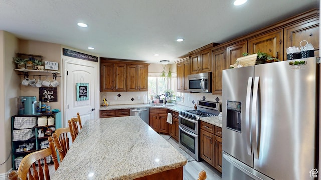 1605 W 1400 S, Vernal, UT 84078 - kitchen with stainless steel appliances, recessed lighting, brown cabinets, light stone counters, and hanging light fixtures