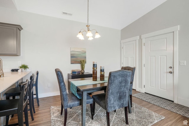 13054 S Tortola Dr W Unit 301, Herriman, UT 84096 - dining space featuring wood finished floors, a chandelier, and lofted ceiling