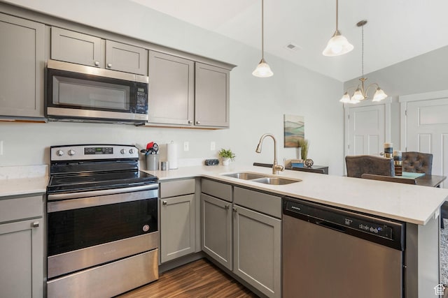 13054 S Tortola Dr W Unit 301, Herriman, UT 84096 - kitchen with gray cabinetry, appliances with stainless steel finishes, a peninsula, and vaulted ceiling