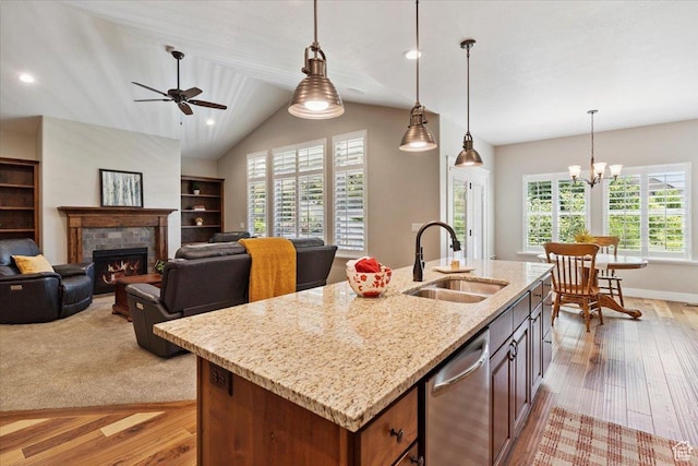 2681 E Sunshine Ct S, South Weber, UT 84405 - kitchen with dishwasher, light wood-style flooring, a tile fireplace, hanging light fixtures, and vaulted ceiling